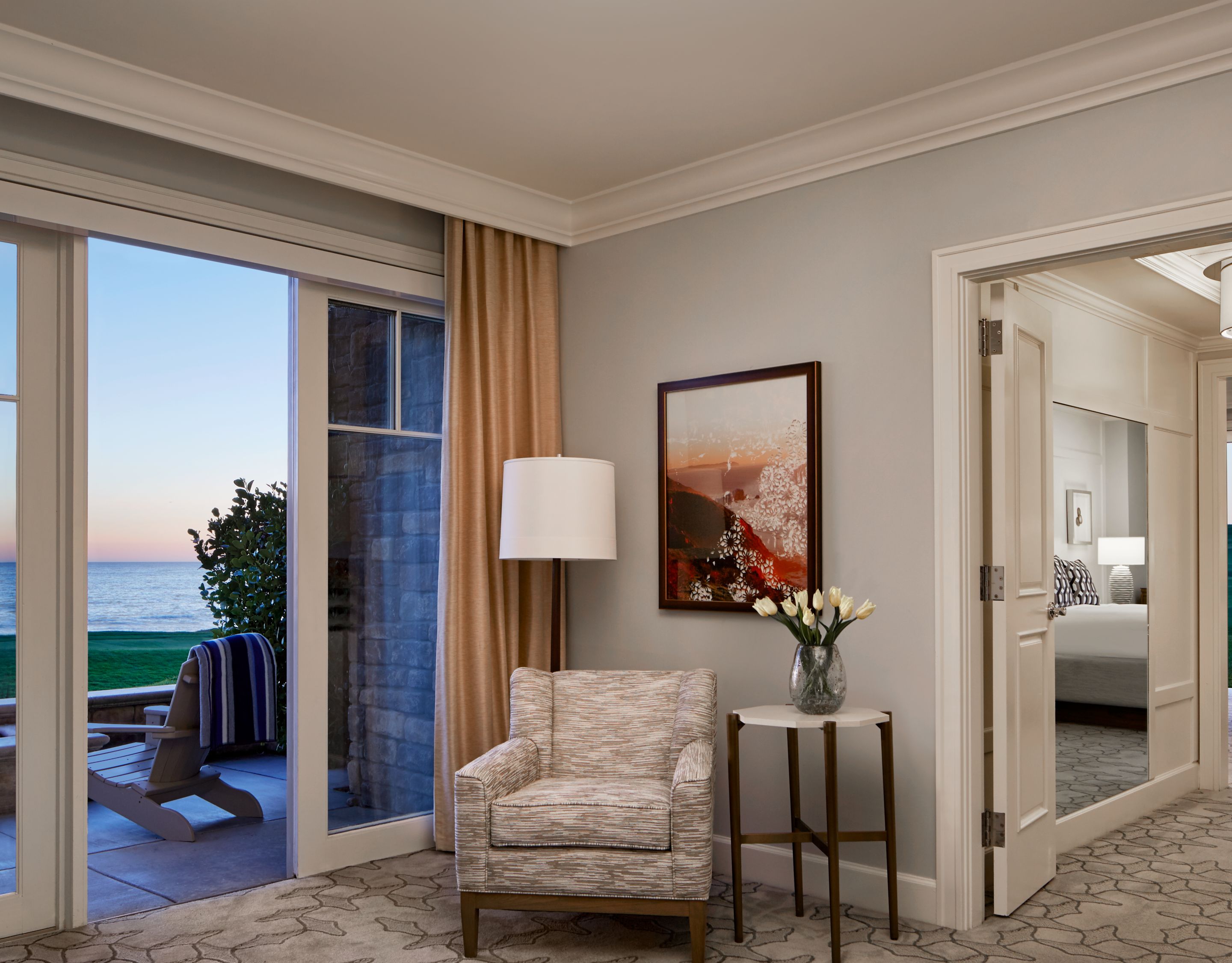 A living room leading to a bedroom on one side and an outdoor patio on the other