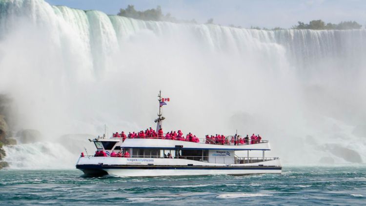 boat on the water with falls in the background