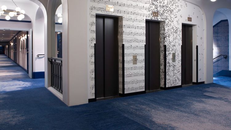 Hotel elevator corridor with sheet music graphic on the wall.