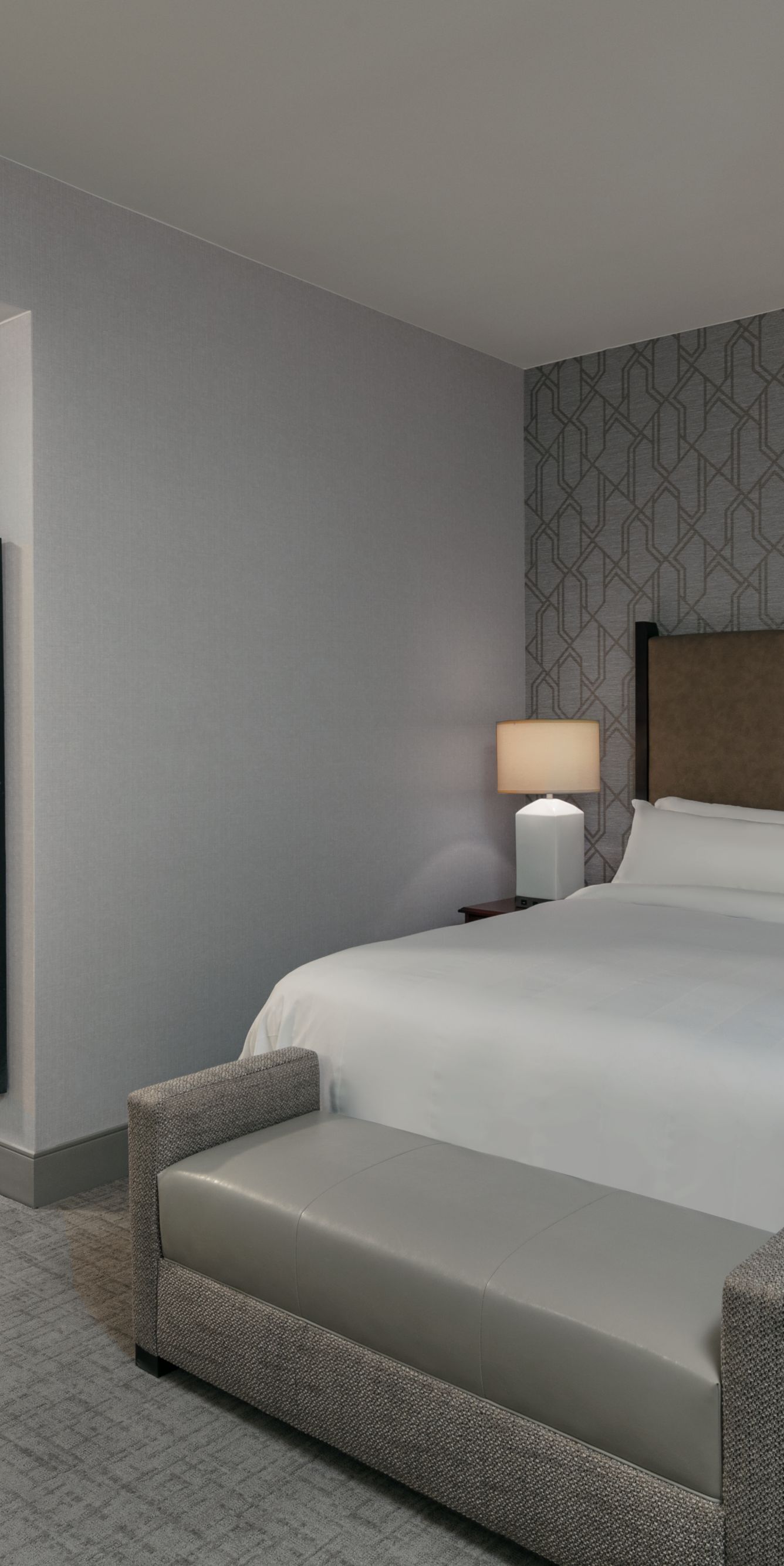 Junior Suite with king bed, bench seating, and hallway entrance. 