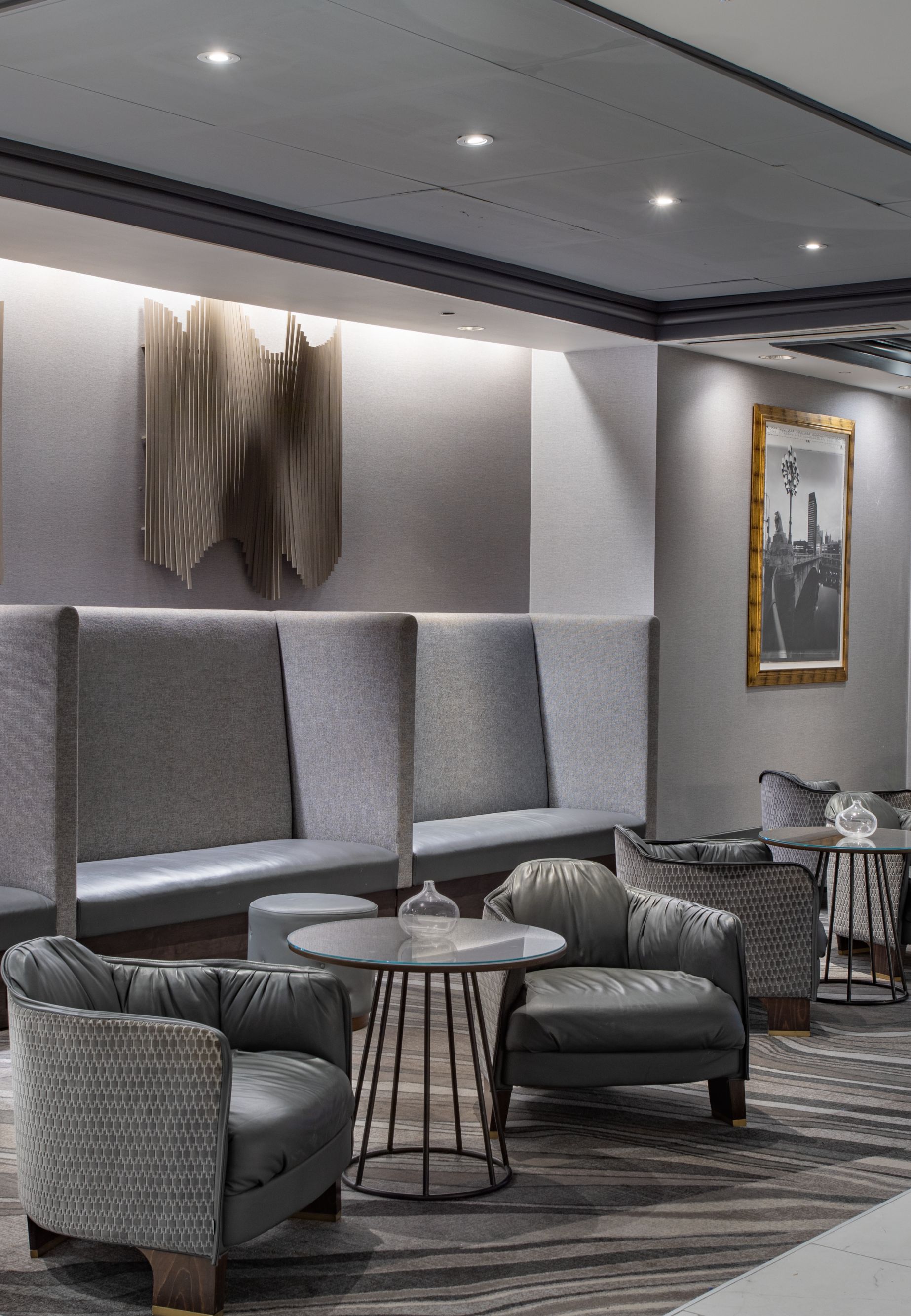 Lobby seating with benches long the far wall, inset lighting, and tables. 