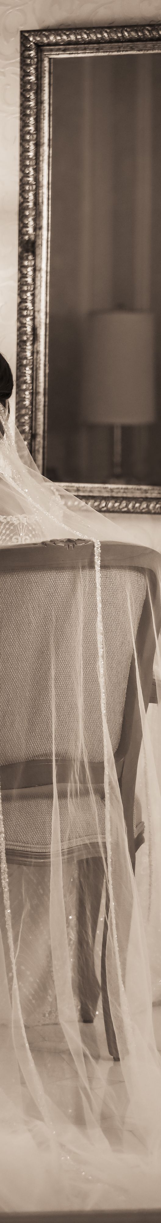 A black and white image of a bride sitting with her back to the camera.