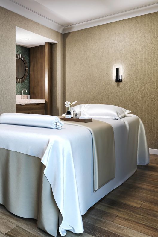 Spa room with a massage bed with silk sheets and pillow. 
