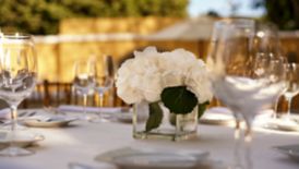 A table set with formal place settings and a floral centerpiece