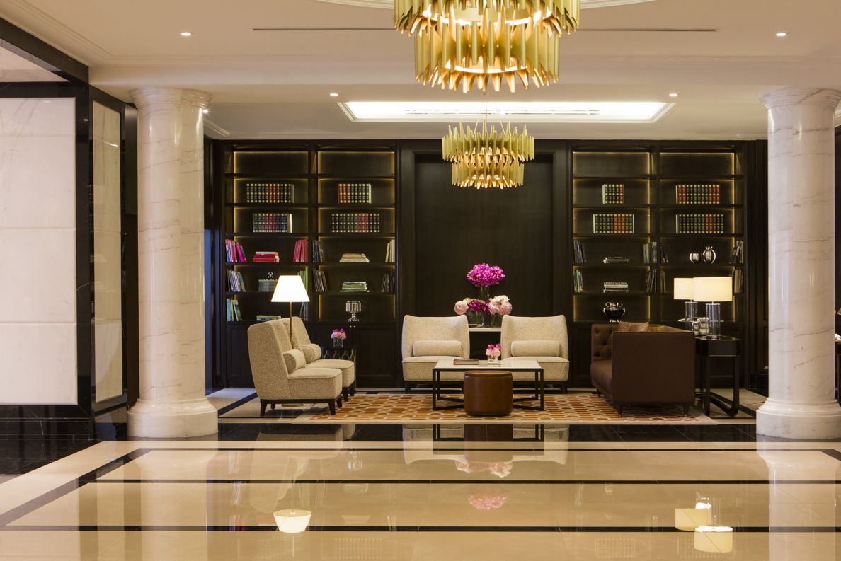 Intimate seating in a space to the side of the lobby where floor-to-ceiling bookcases create a cozy ambience