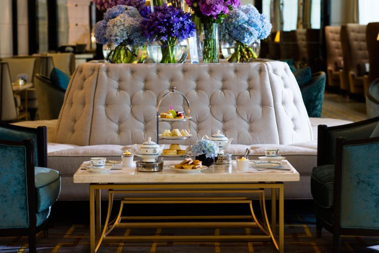 Afternoon Tea in The Lobby Lounge with tufted benches, plush armchairs and extravagant purple floral displays