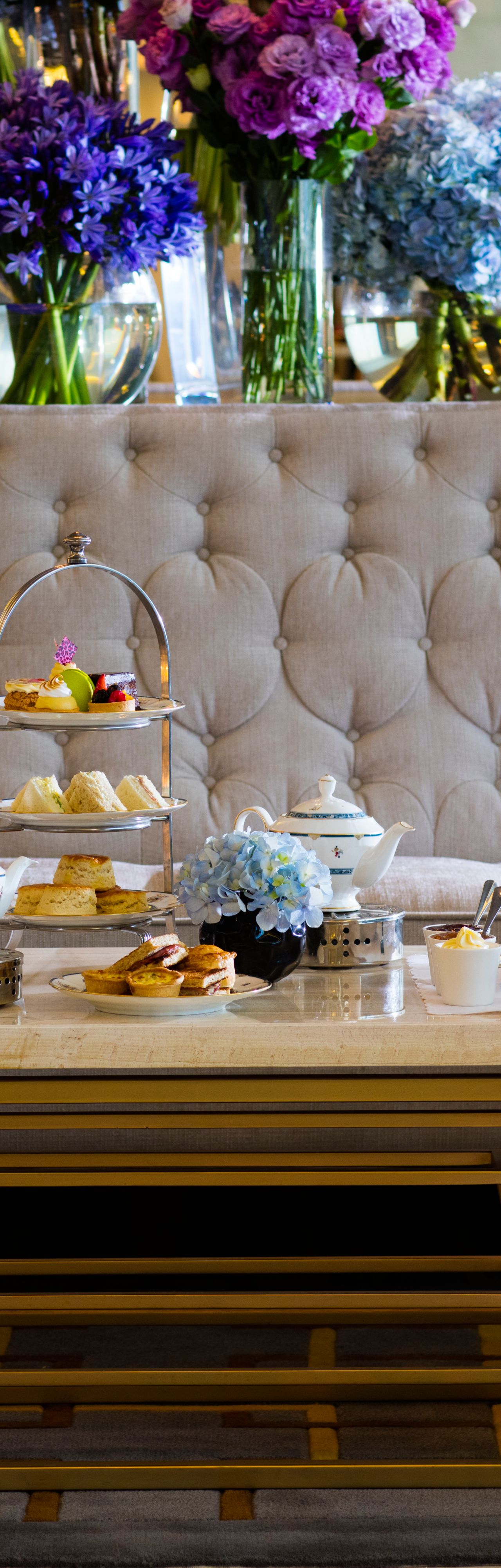 Afternoon Tea in The Lobby Lounge with tufted benches, plush armchairs and extravagant purple floral displays
