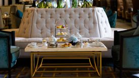 Afternoon Tea in The Lobby Lounge with tufted benches, plush armchairs and extravagant purple floral displays