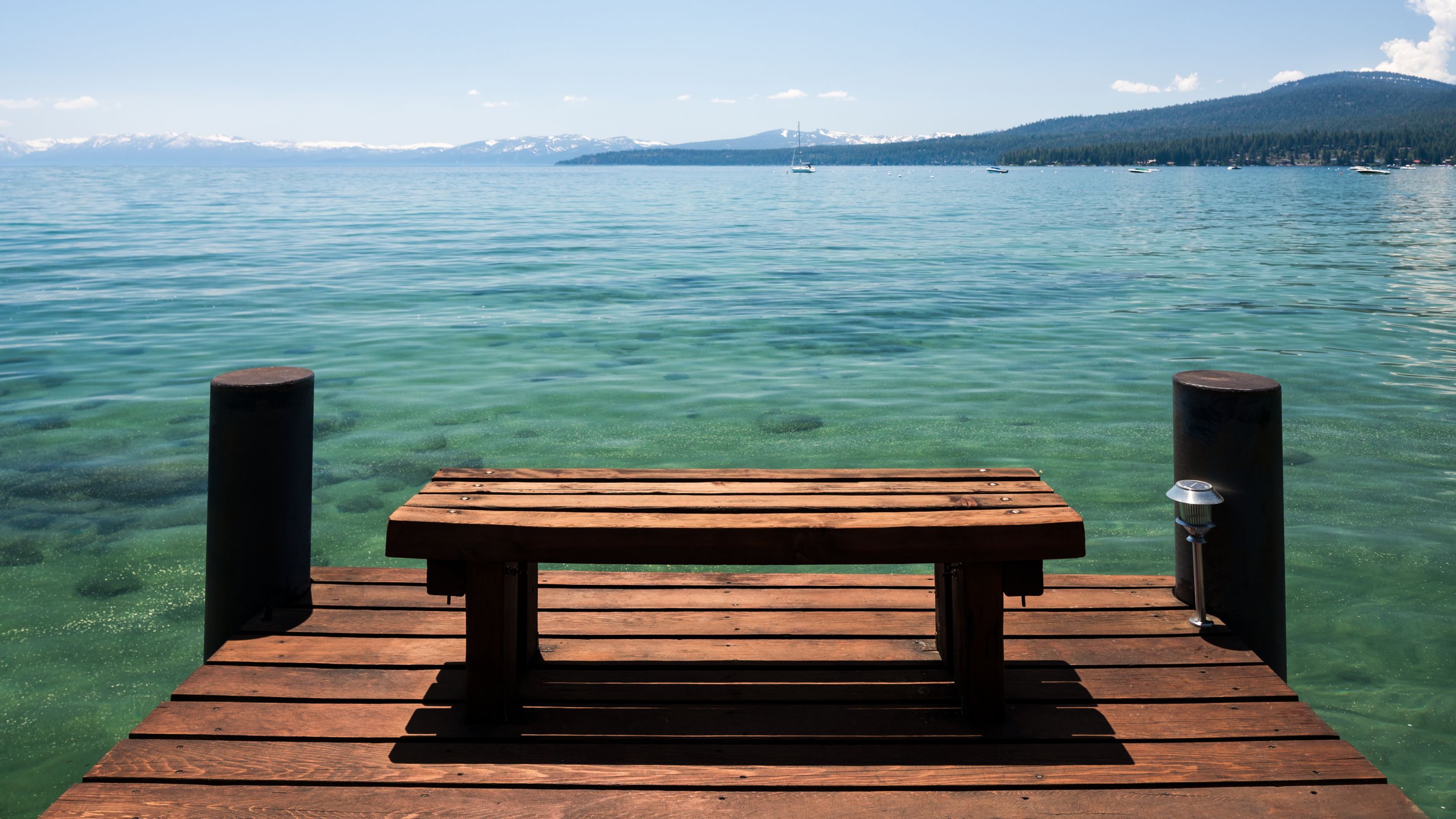 A wooden bench on a pier overlooking a lake