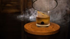 Smoke pours out of a cocktail glass