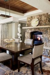 Dining room and living room separated by a stone fireplace