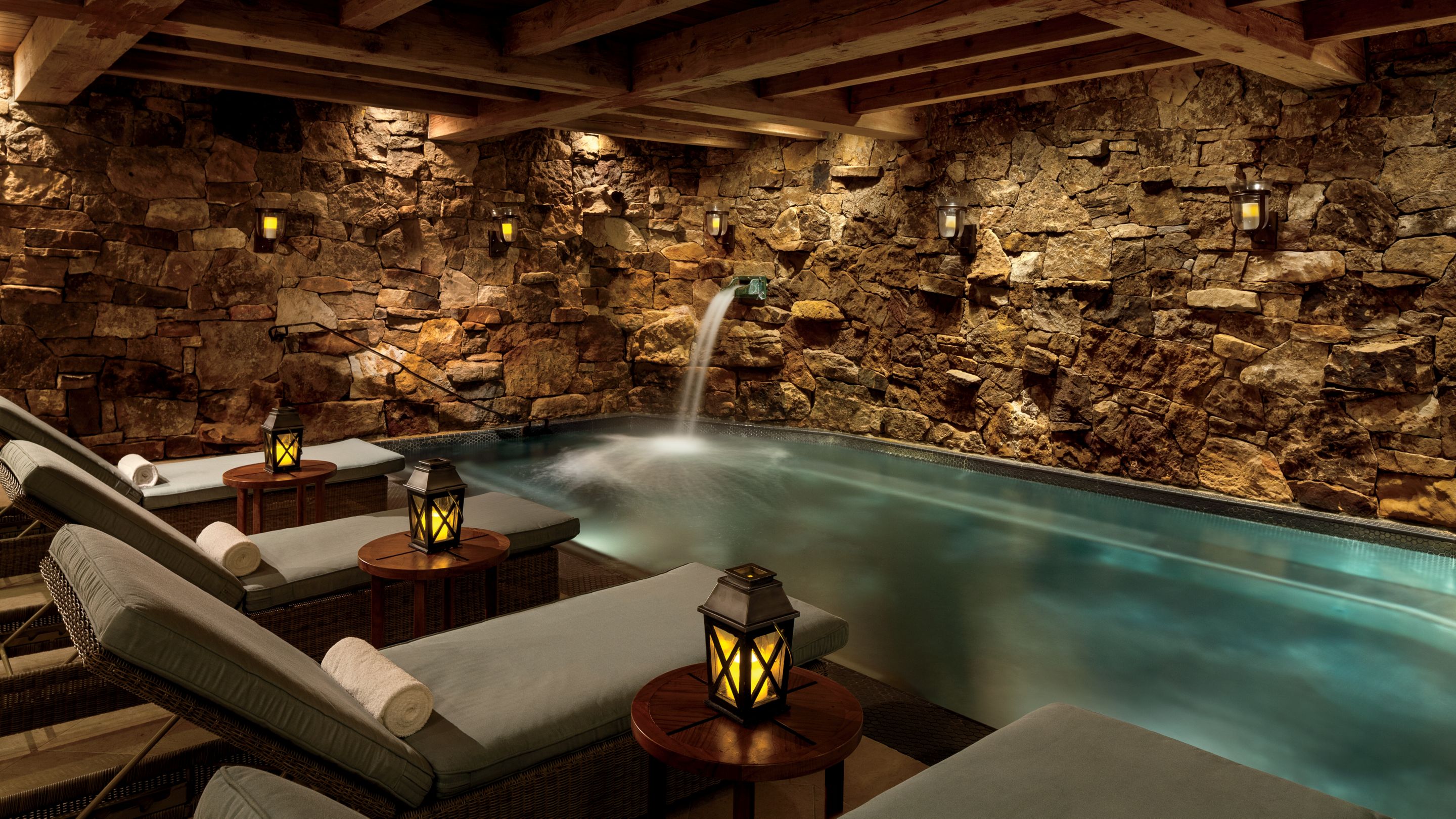 Indoor pool with stone walls and lounge chairs