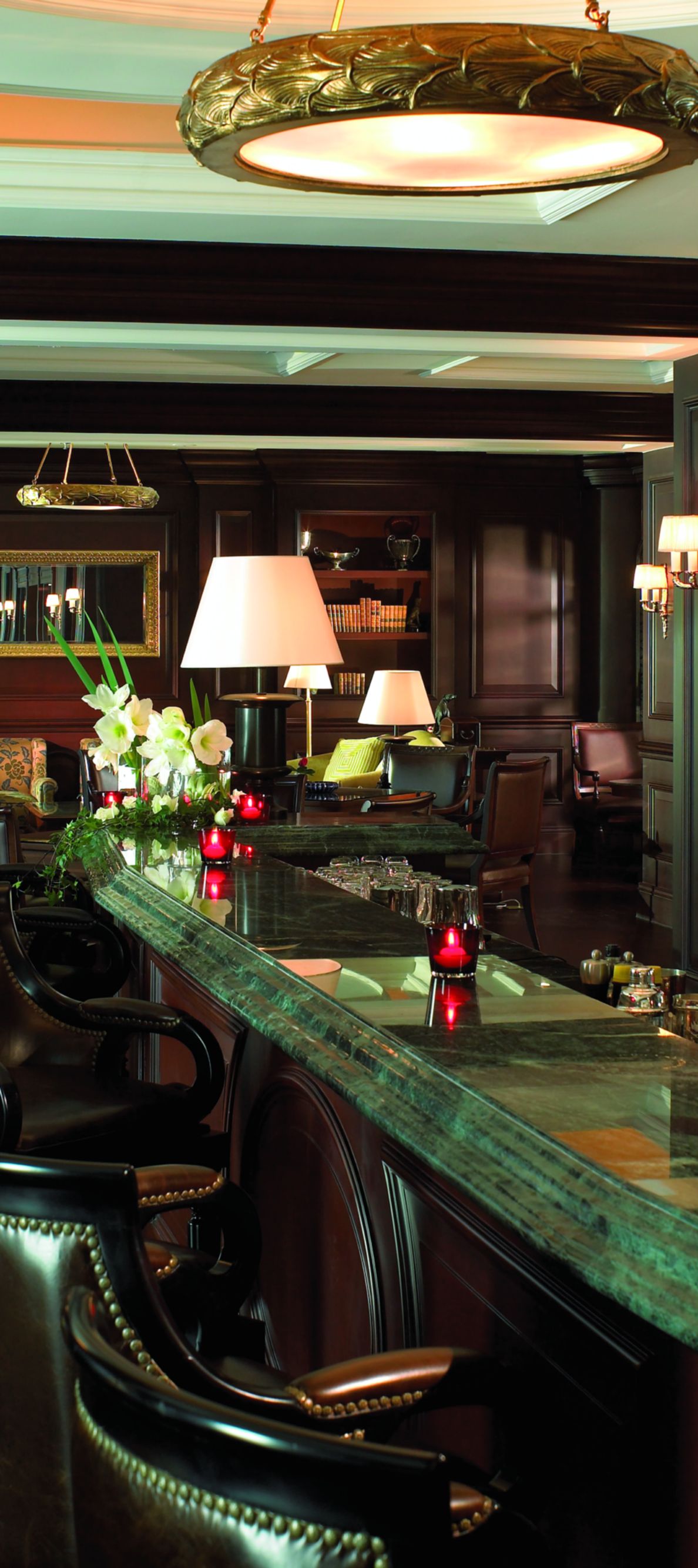 Leather stools lined up at a marble bar