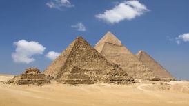 Pyramids and desert against a bright blue sky