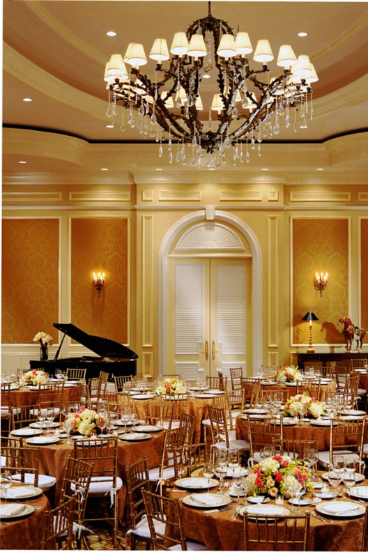 Large event setup with warm tones and gold details on the tables. 