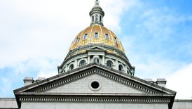 The dramatic entrance of the Colorado State Capitol Building with Corinthian columns and a gold-plated dome