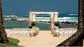 Rows of chairs on the beach facing an oceanfront gazebo