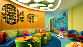 Playroom featuring an aquatic theme with shelving shaped like fish, a mural and colorful seating