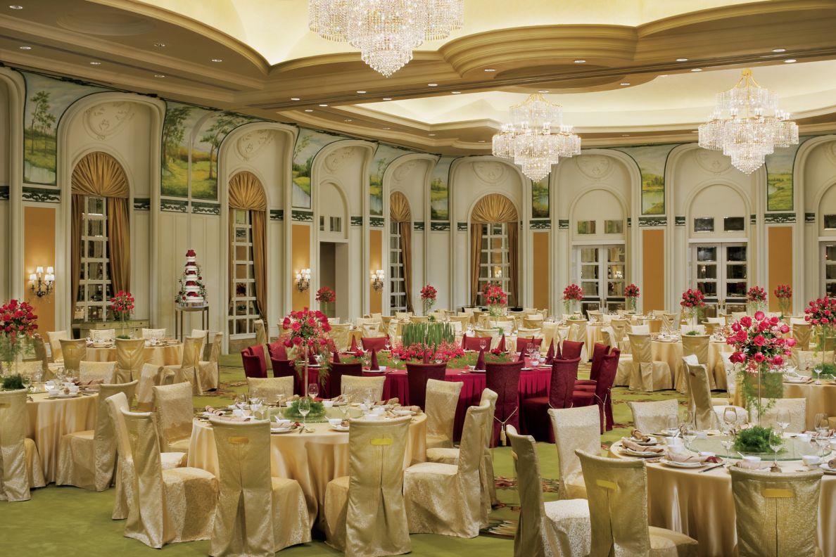 A large ballroom with many tables and chairs throughout.