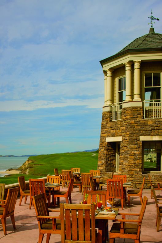 Patio, filled with dining tables and a large tower, overlooking the ocean