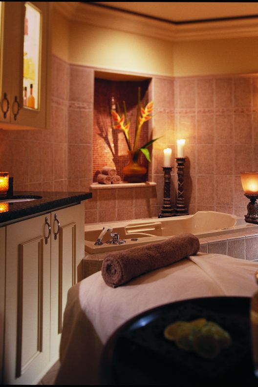 A decorated and lit spa room with a massage table.