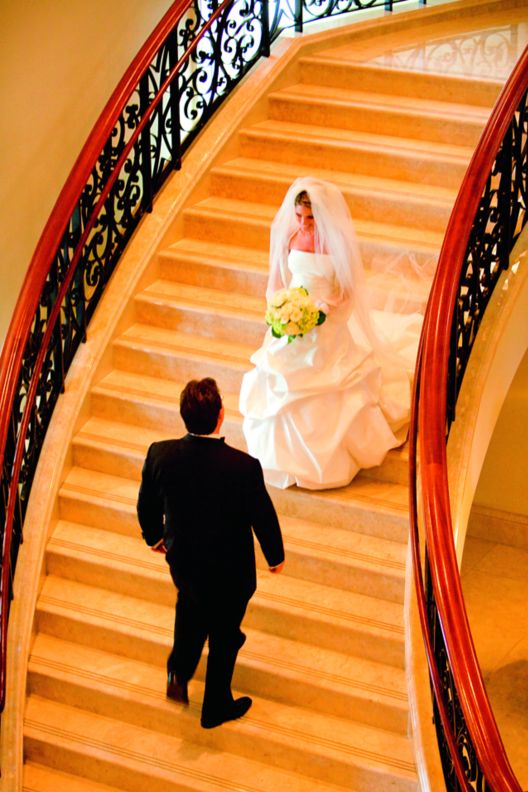 A bride and groom on a staircase.