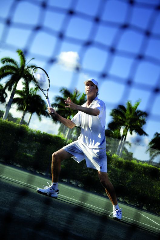 Someone playing tennis at the resort.