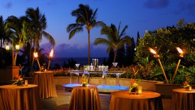 Sunset and tiki torches create an intimate ambience on the Plantation Lanai