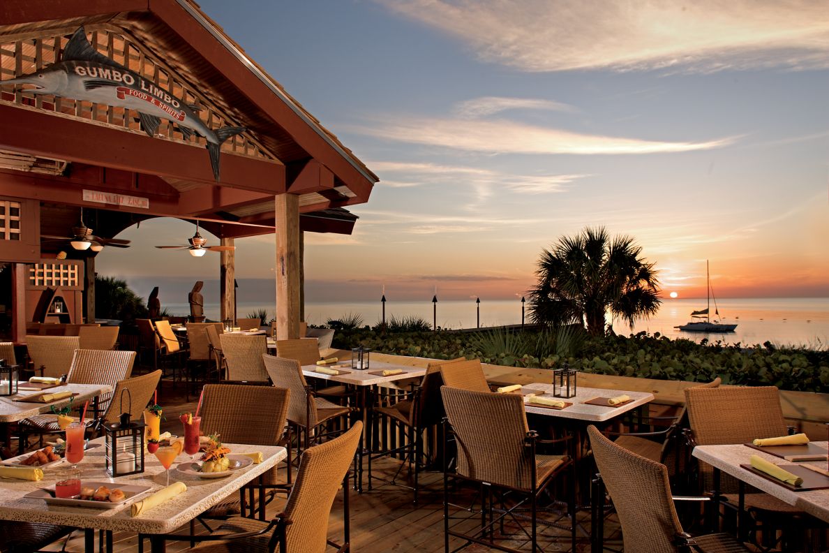 An outdoor dining area with the ocean in the background.