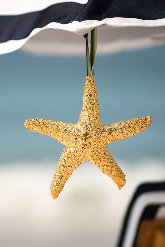 A decorative starfish hanging from a beach umbrella.