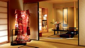 Room with traditional Japanese furniture and décor, including a low table with floor seating and a kimono