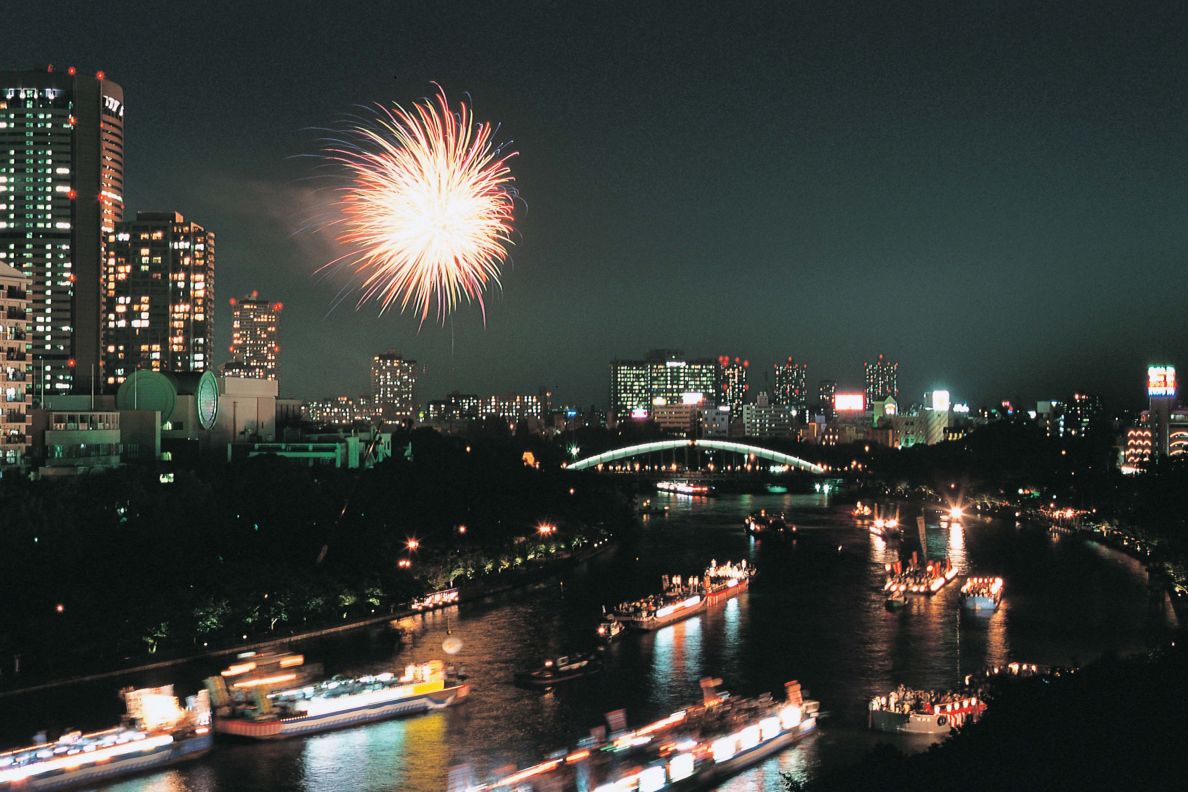Tenjin Matsuri with fireworks and boats in the river.