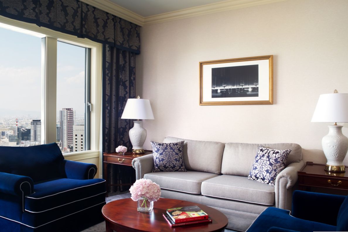 Executive suite with sofa, two chairs and a view of the city.