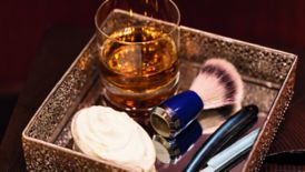 Tray with a glass of scotch, a shaving brush, razor blade and shaving cream