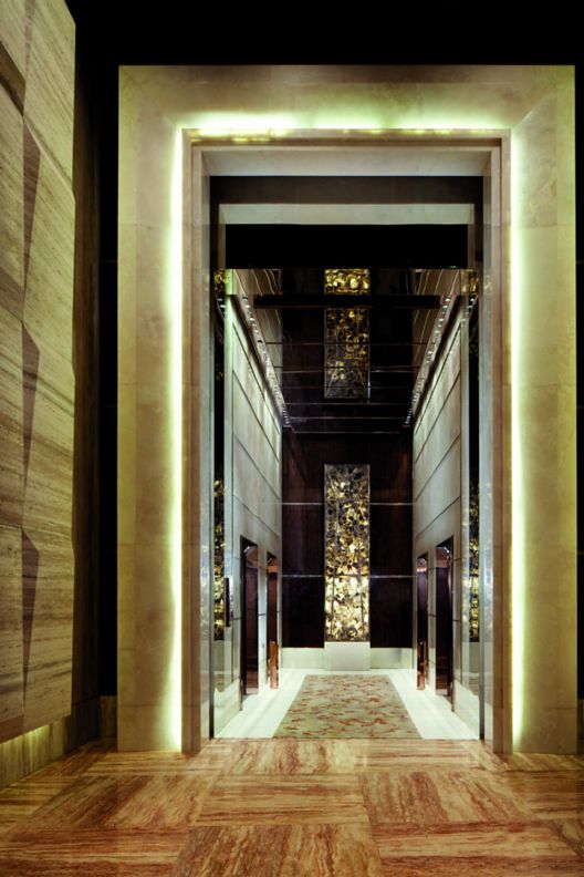 Corridor in black and gold with soaring proportions and tactile walls.