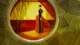 Small portrait of a woman depicted in traditional Chinese attire as viewed through a circular metal frame