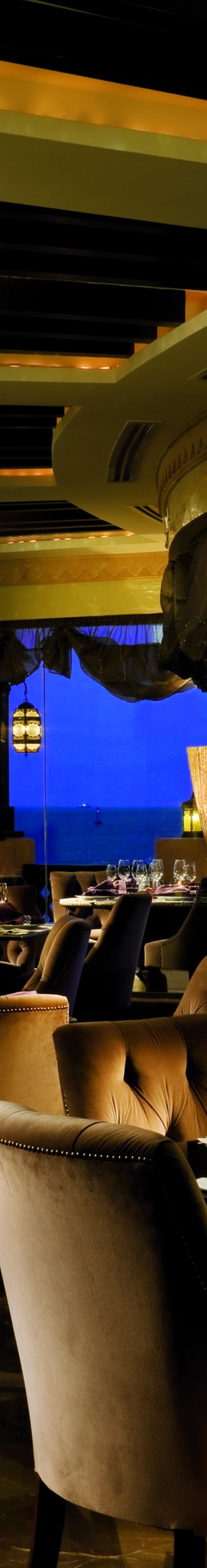 Restaurant with a night time view of the sea.