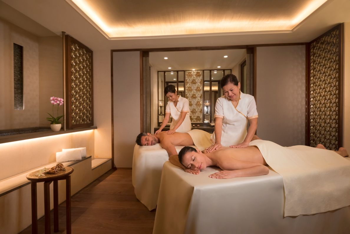 A man and a woman laying on twin massage beds getting a massage.