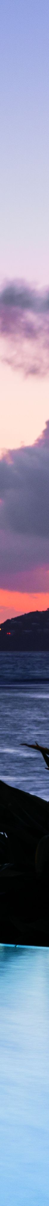 A pool appears to lead into the ocean at sunset