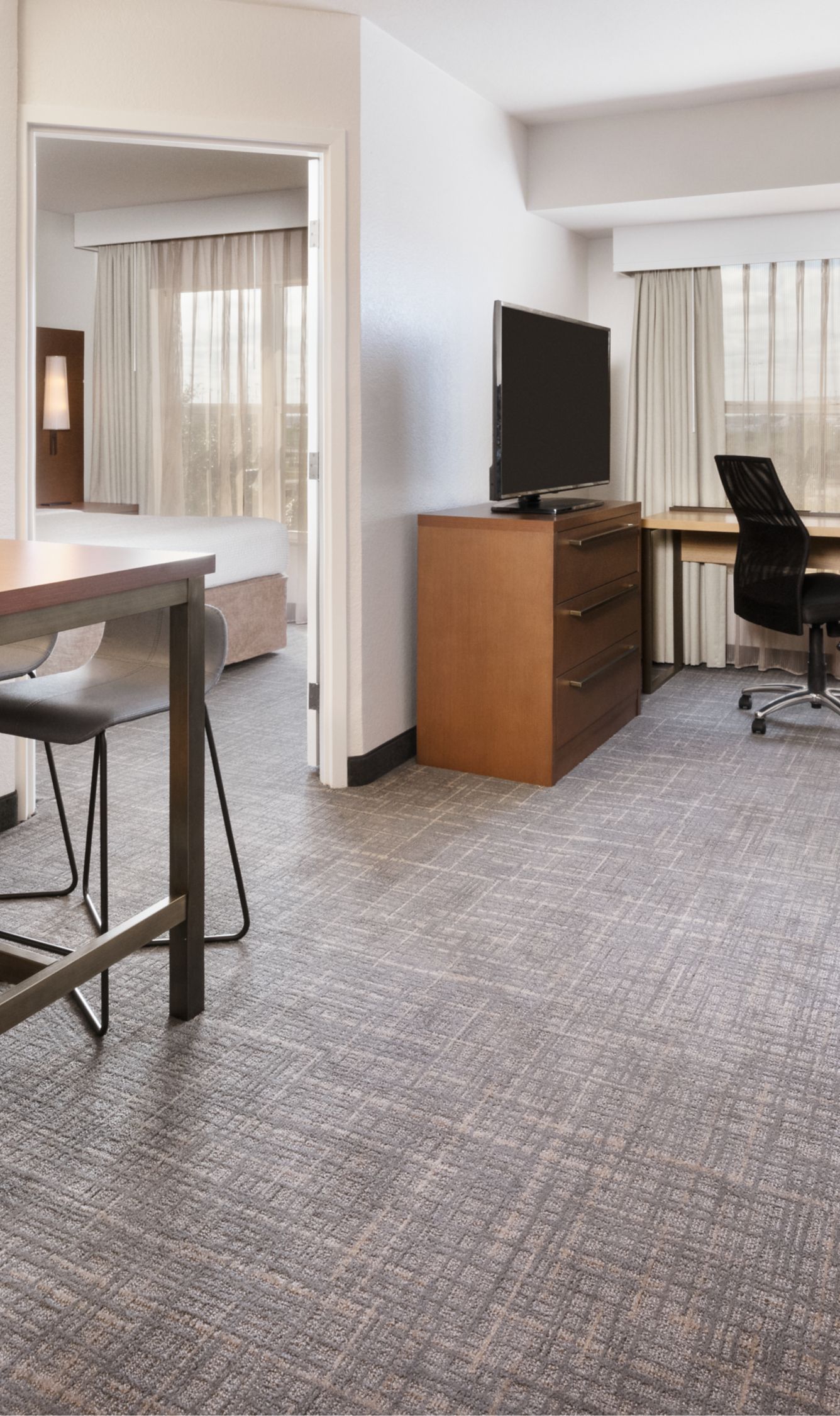 suite living room with sofa, table, desk, and tv