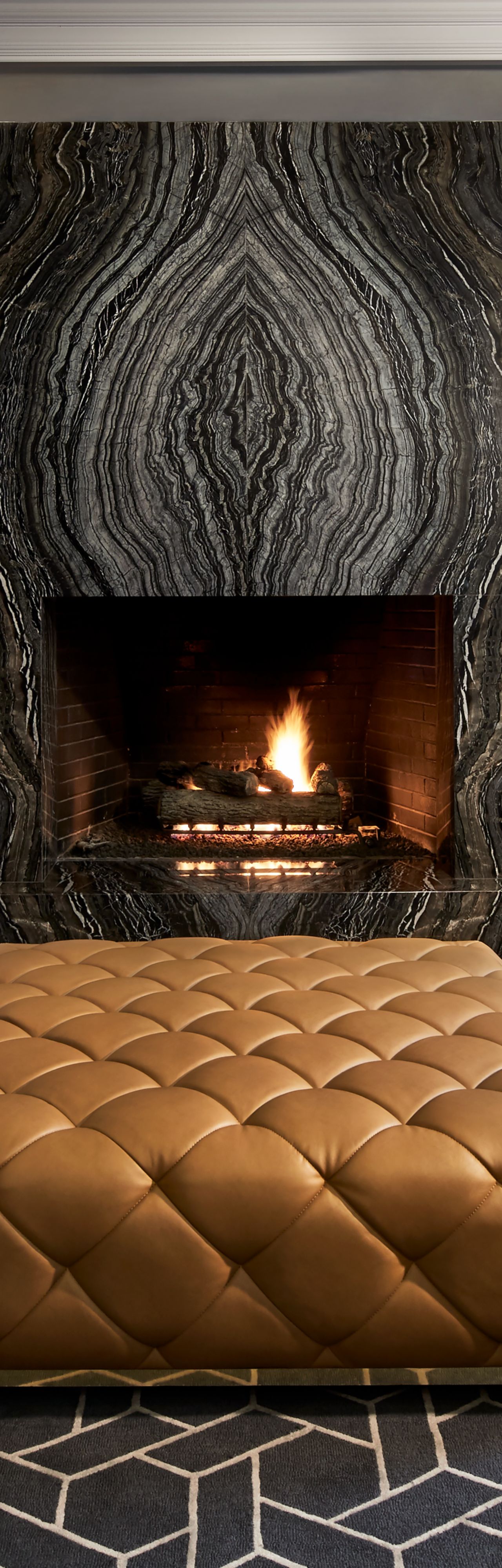 A banquette-lined room with a fireplace, bookshelves and a tufted "table"