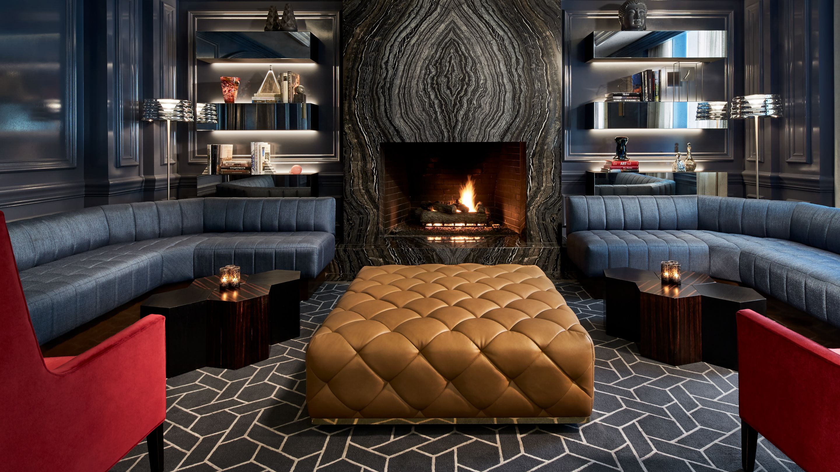 A banquette-lined room with a fireplace, bookshelves and a tufted "table"