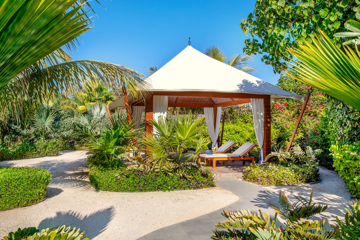Garden cabana with white tent tops and garden walkway path. 