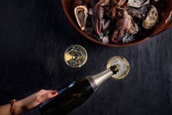 Champagne poured in glass with seafood platter