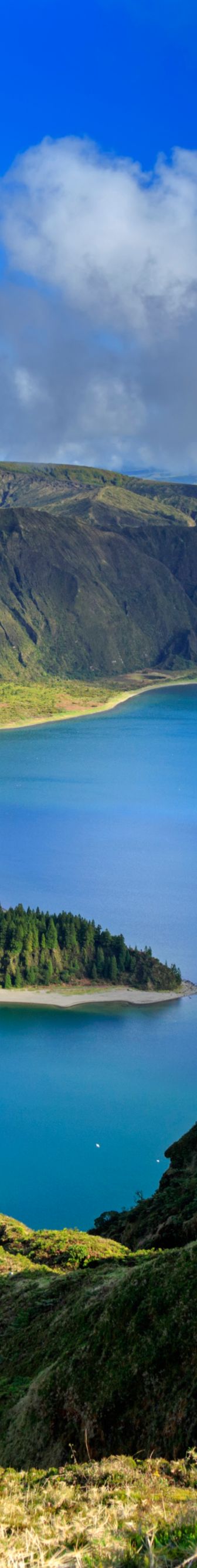 A blue lake is surrounded by green hills