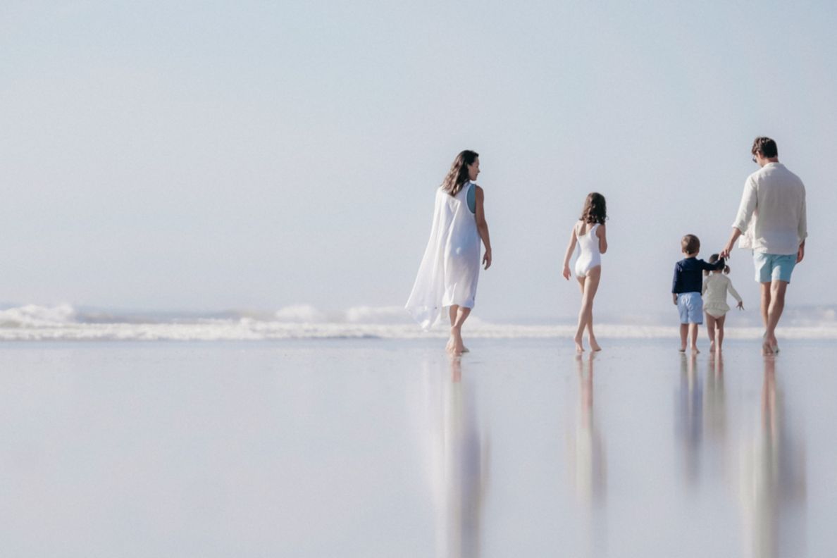 Family of four walking along the beach.