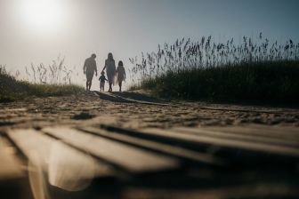 Family of four walking towards the beach.
