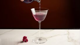 Purple cocktail being poured