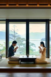 Couple enjoying tea by a window overlooking a lake
