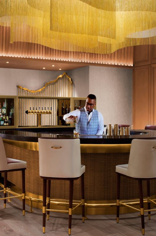 U-shaped bar with chairs around it and bartender p